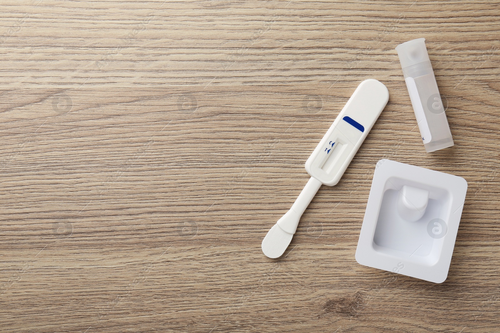 Photo of Disposable express test kit on wooden table, flat lay. Space for text