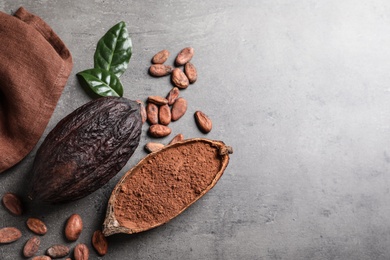 Photo of Flat lay composition with cocoa beans and pods on grey table. Space for text