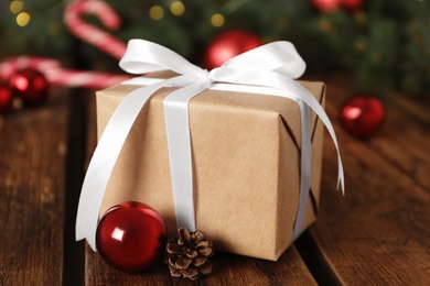 Photo of Christmas gift box and decor on wooden table, closeup