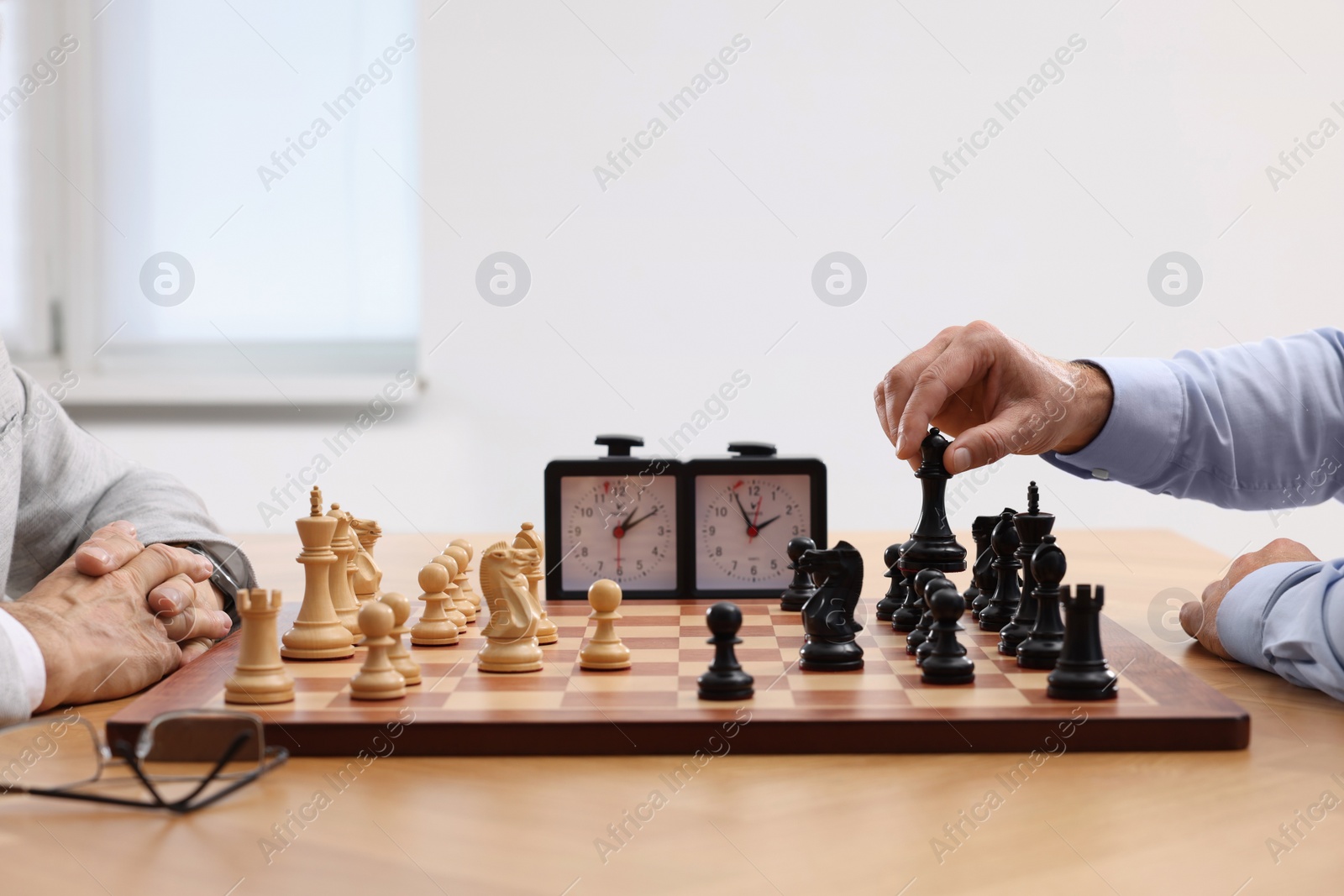 Photo of Men playing chess during tournament at table indoors, closeup