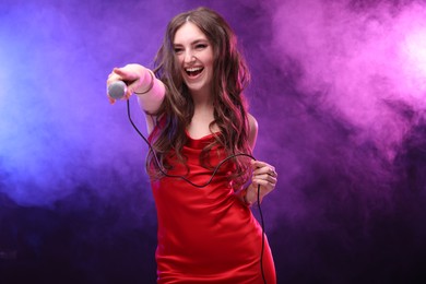 Photo of Emotional singer giving microphone to others in color lights