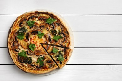 Photo of Delicious quiche with mushrooms and parsley on white wooden table, top view. Space for text