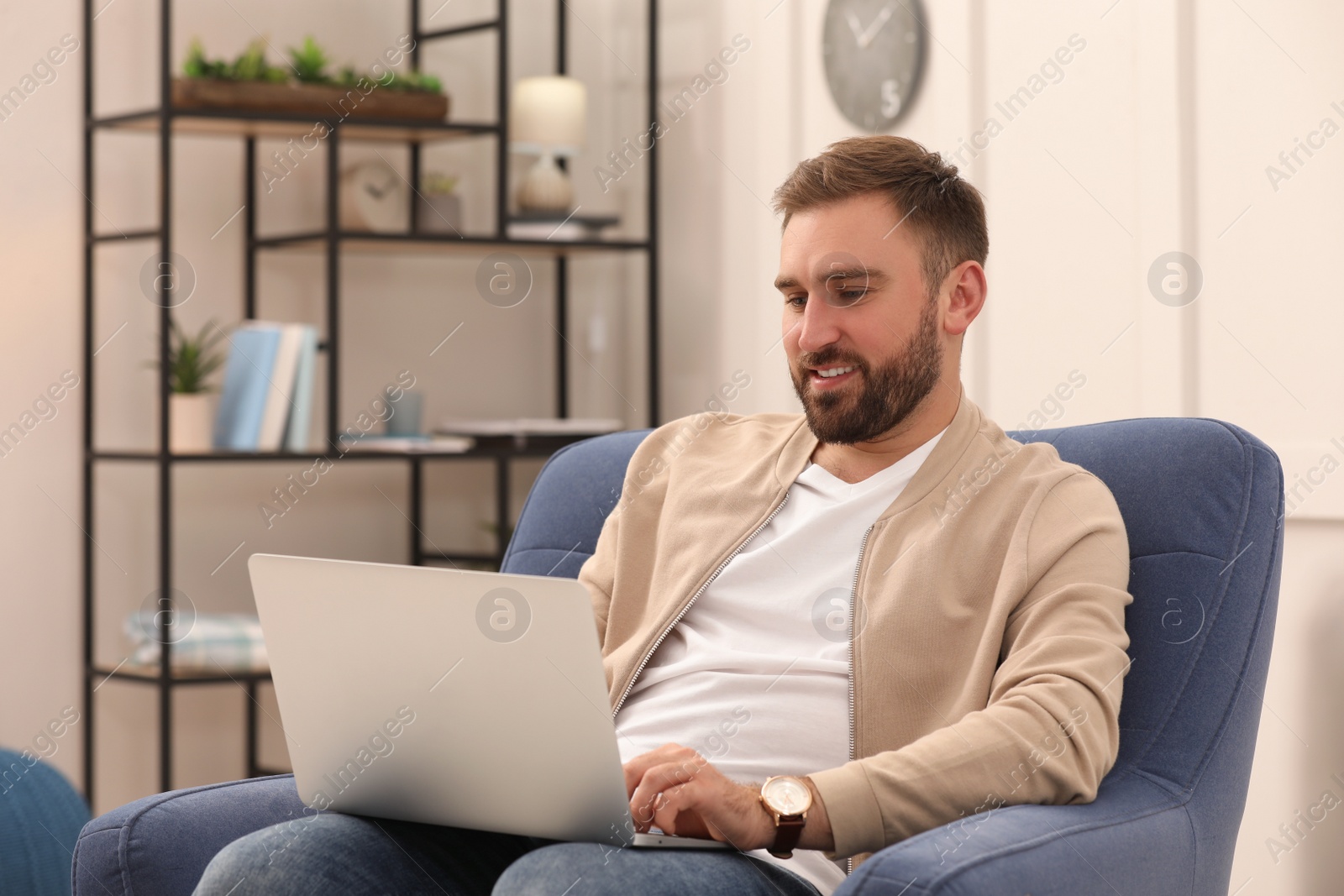 Photo of Young man working with laptop at home