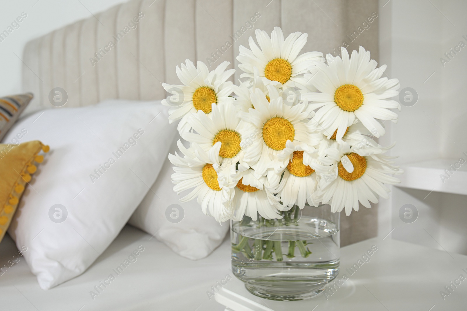 Photo of Bouquet of beautiful daisy flowers on table in bedroom, space for text