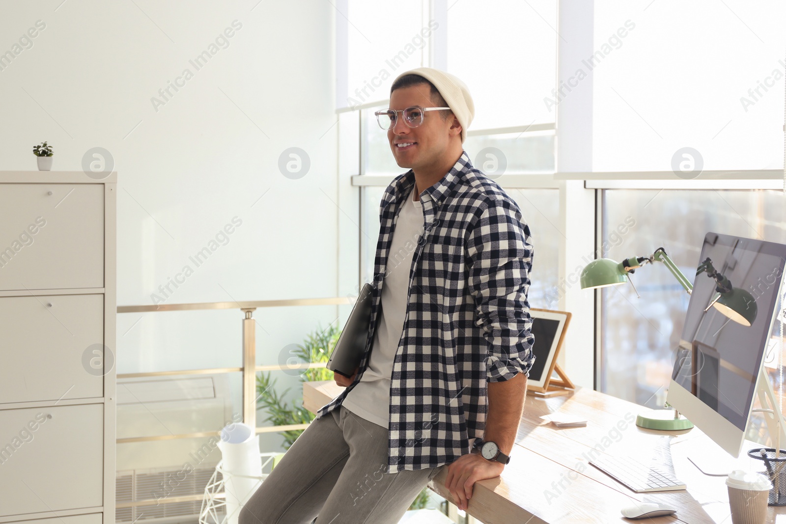 Photo of Freelancer with laptop near workplace indoors. Space for text