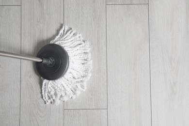 Photo of Cleaning of parquet floor with mop, top view. Space for text