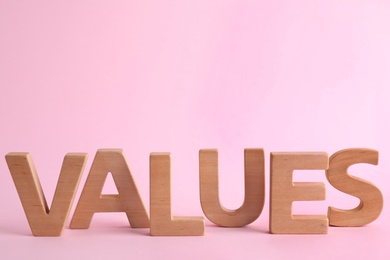 Photo of Word VALUES made of wooden letters on pink background