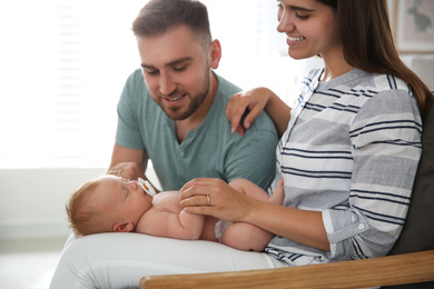 Happy couple with their newborn baby at home