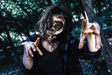 Photo of Scary zombie with bloody face outdoors. Halloween monster