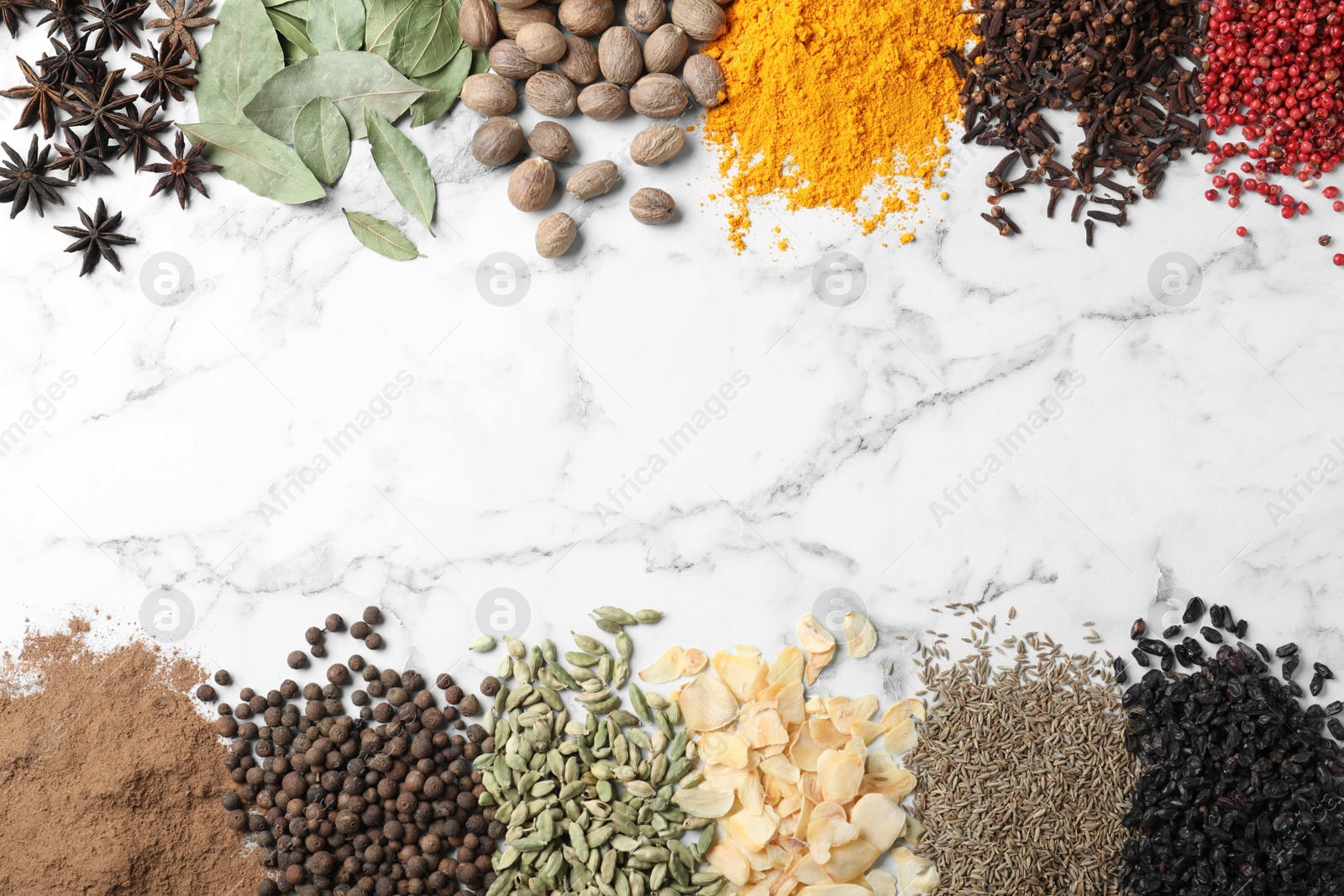 Photo of Many different spices on white marble background, top view. Space for text