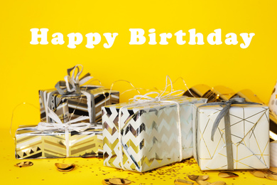 Photo of Gift boxes and text Happy Birthday on yellow background