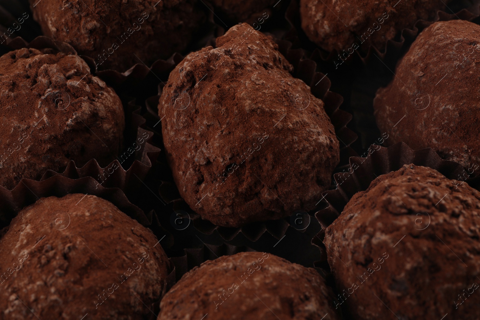 Photo of Many delicious chocolate truffle candies as background, closeup