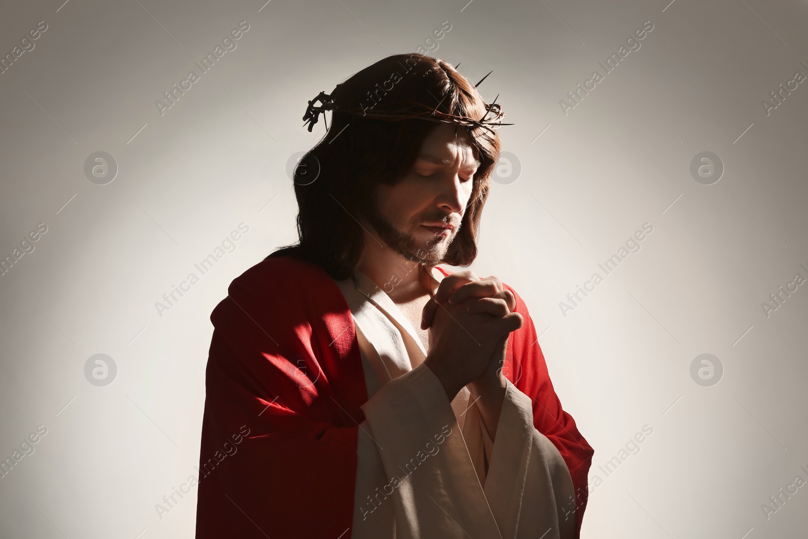 Photo of Jesus Christ with crown of thorns praying on white background