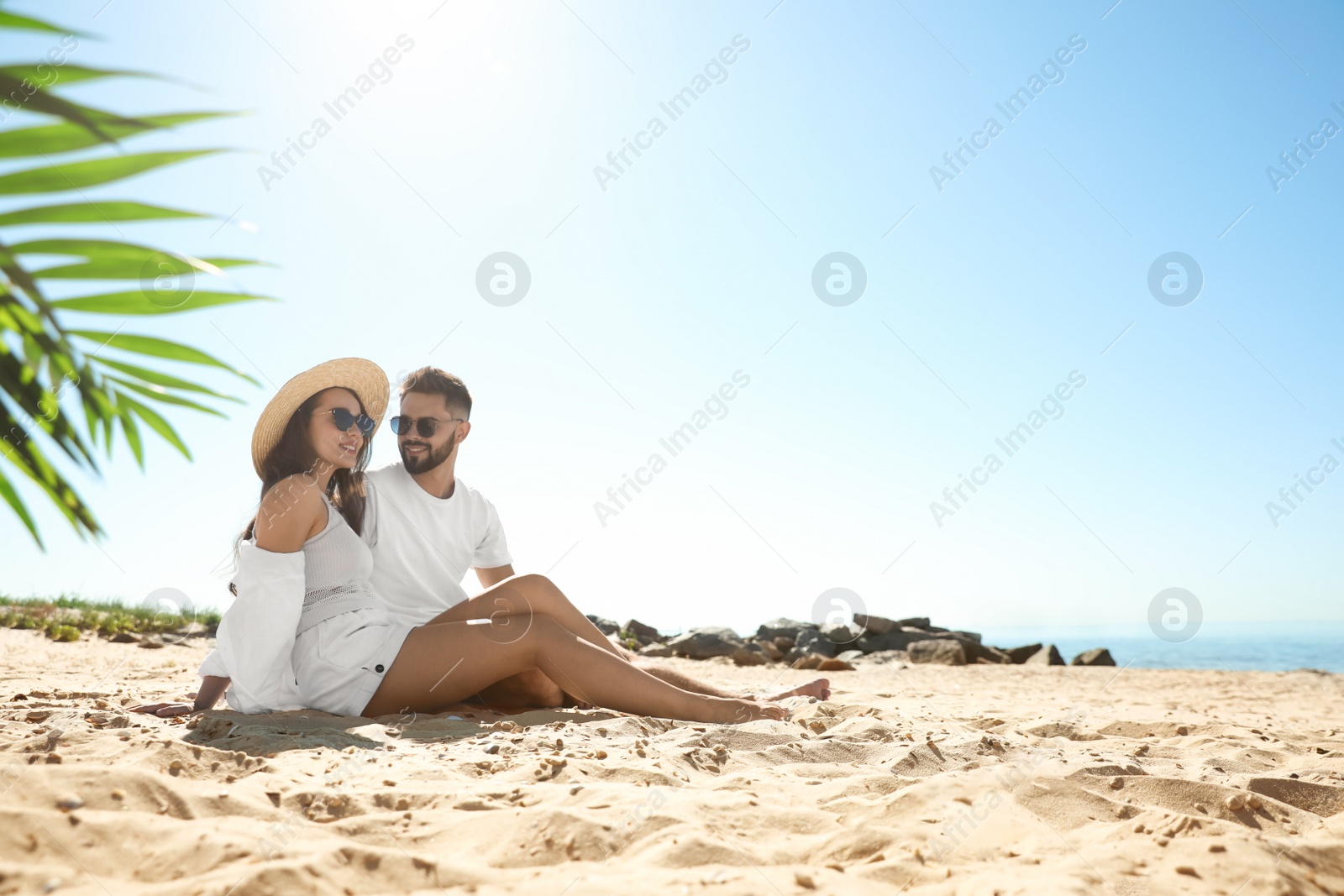 Photo of Happy young couple on beach near sea. Honeymoon trip