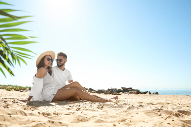 Photo of Happy young couple on beach near sea. Honeymoon trip