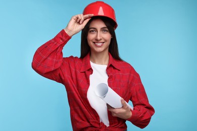 Photo of Architect in hard hat with draft on light blue background