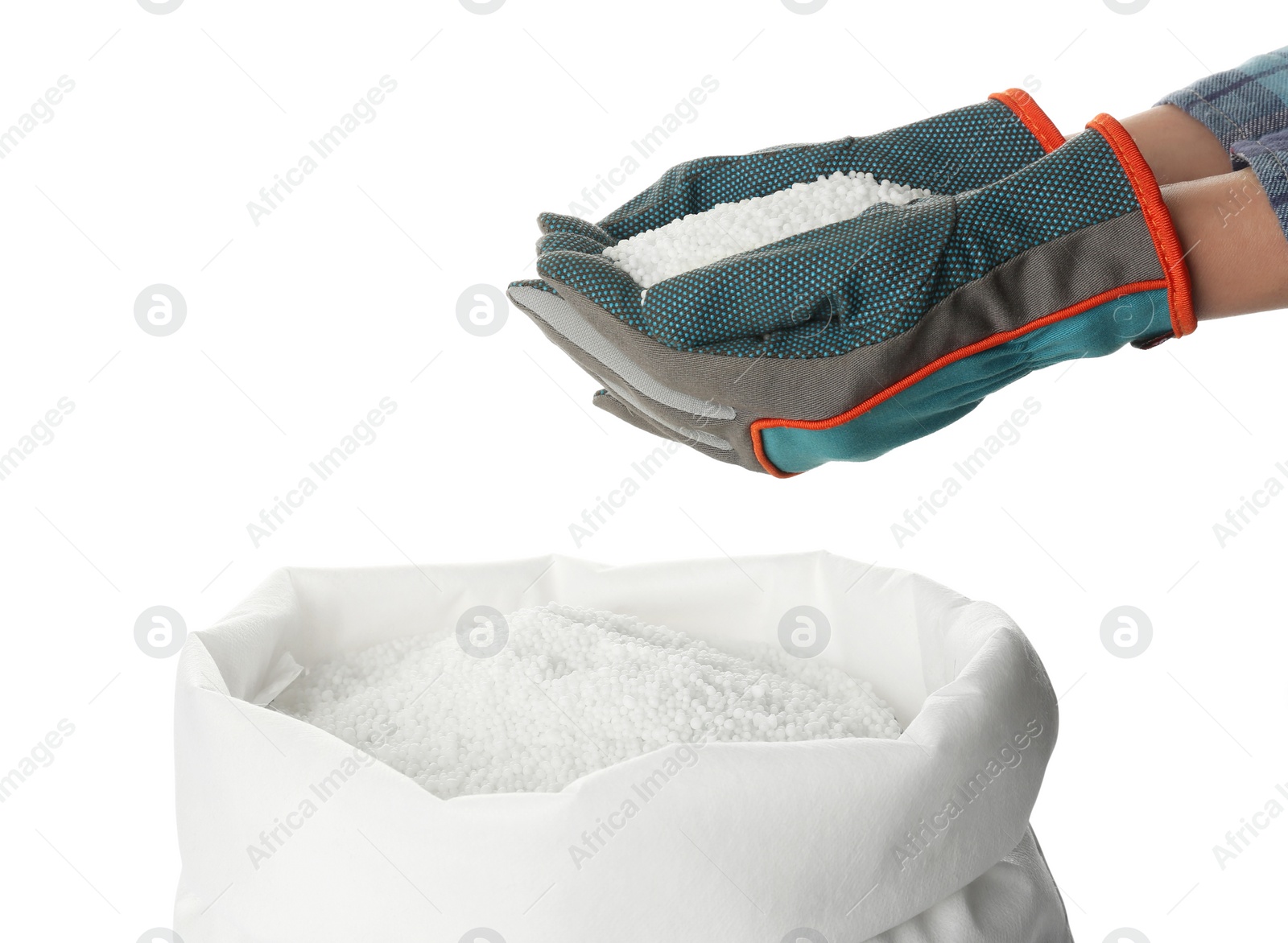 Photo of Man holding ammonium nitrate pellets above sack on white background, closeup. Mineral fertilizer