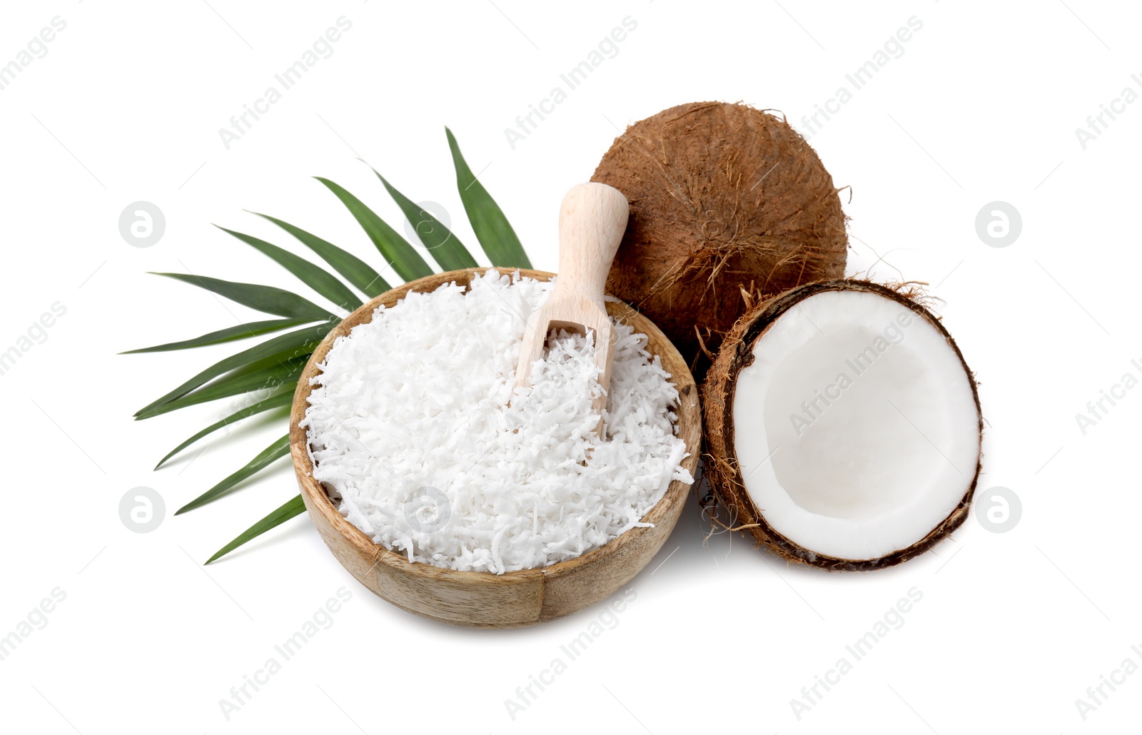 Photo of Coconut flakes in bowl, scoop, nuts and palm leaf isolated on white