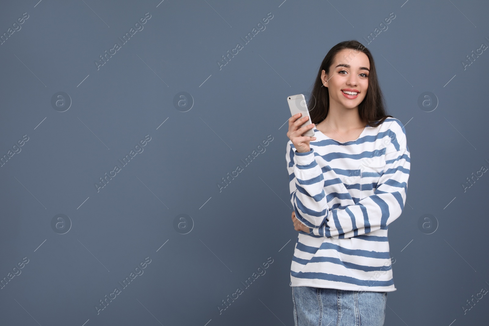 Photo of Young woman using phone on color background