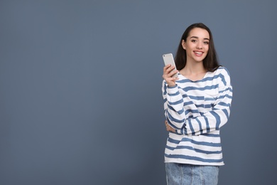 Photo of Young woman using phone on color background