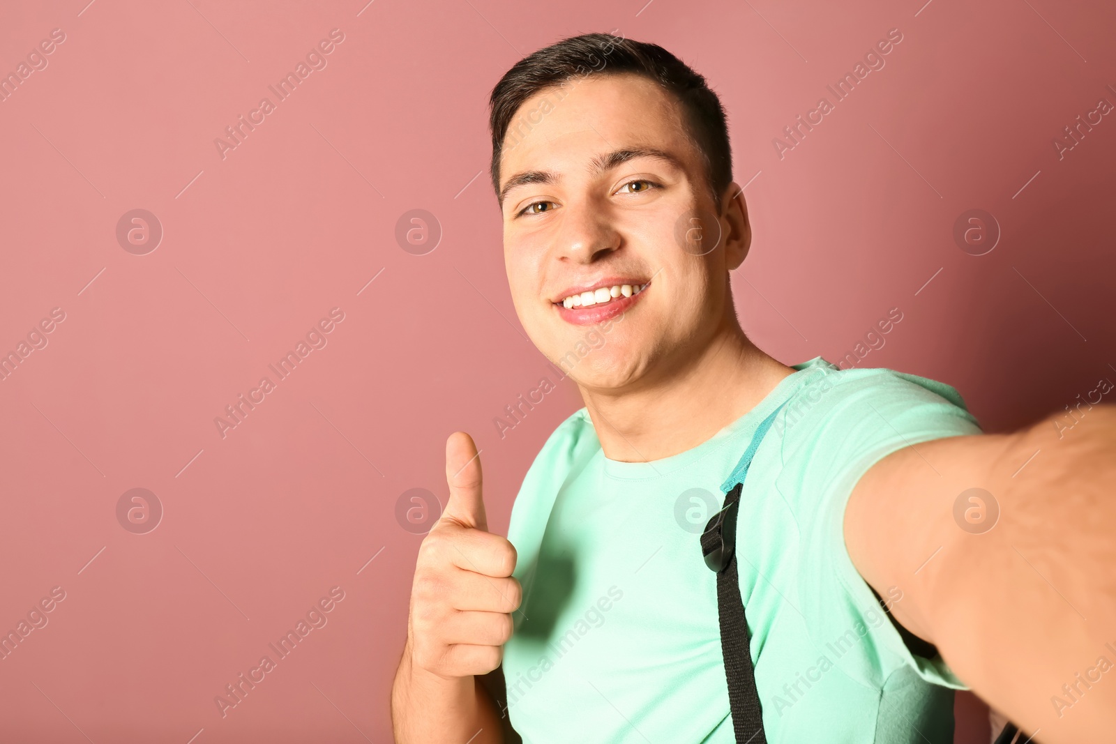 Photo of Young handsome man taking selfie against color background