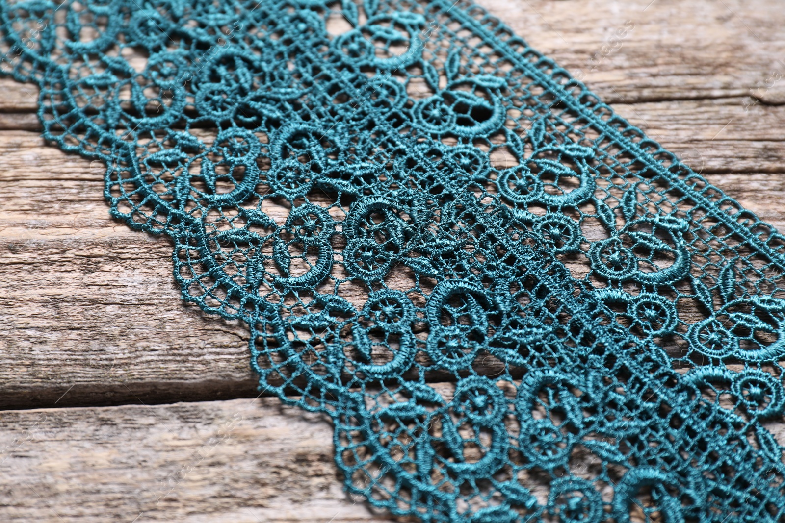 Photo of Beautiful lace on wooden table, closeup view