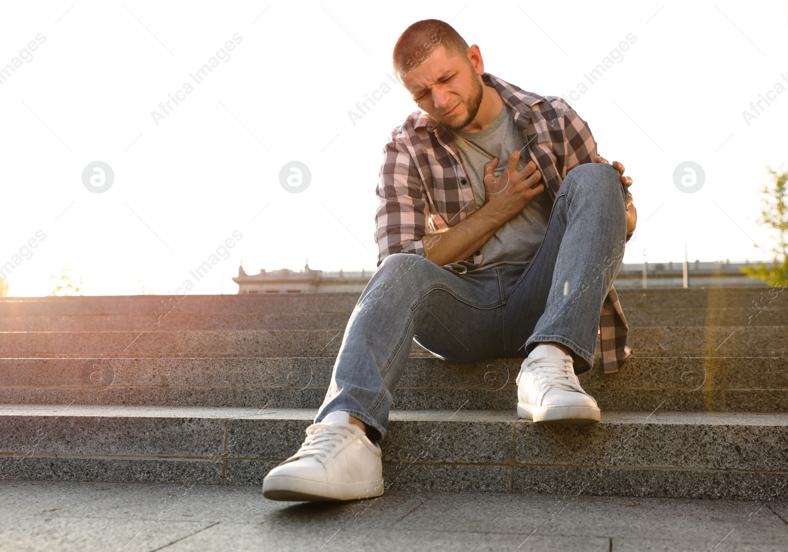 Photo of Man having heart attack on city street