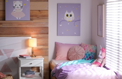 Photo of Bed with beautiful linens in children's room. Modern interior design