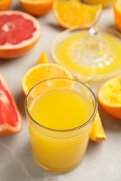 Photo of Freshly made orange juice, fruits and squeezer on table. Space for text