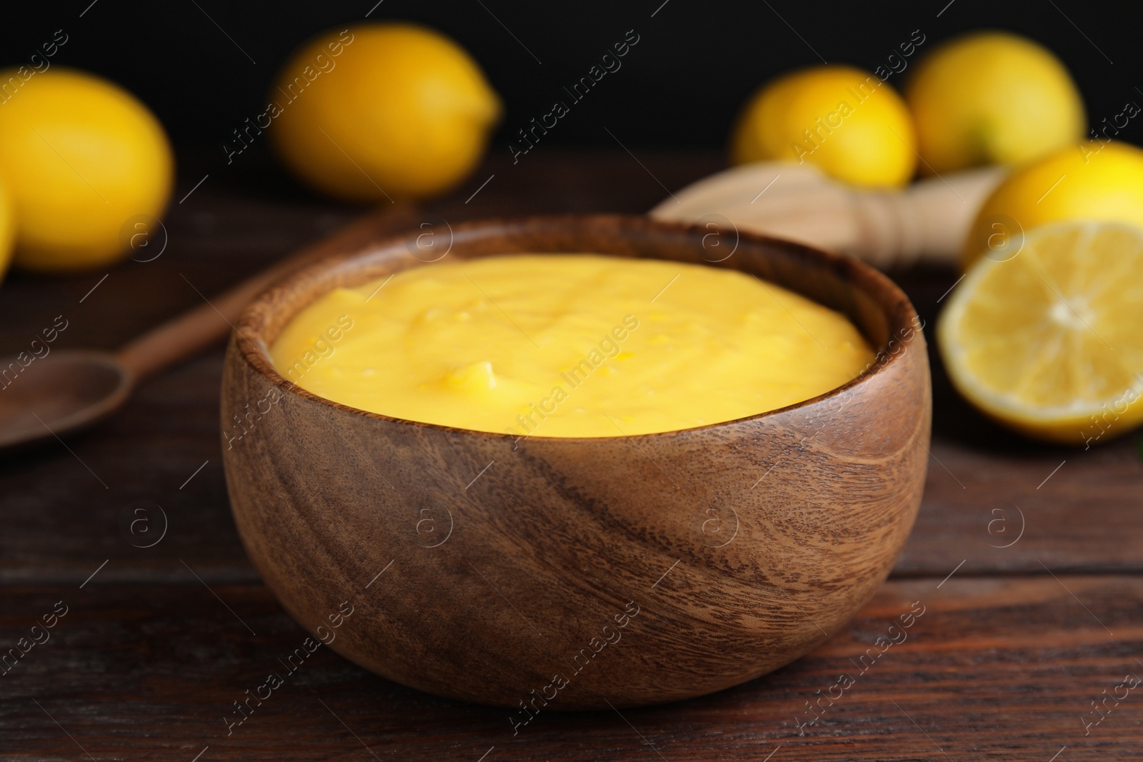 Photo of Delicious lemon curd in bowl on wooden table