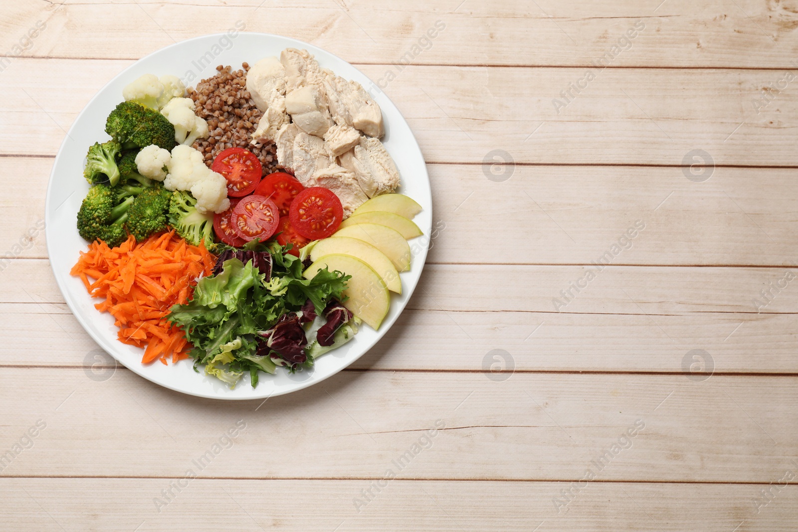 Photo of Balanced diet and healthy foods. Plate with different delicious products on light wooden table, top view. Space for text