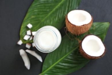 Photo of Bottle of coconut milk with fresh nuts on table, top view