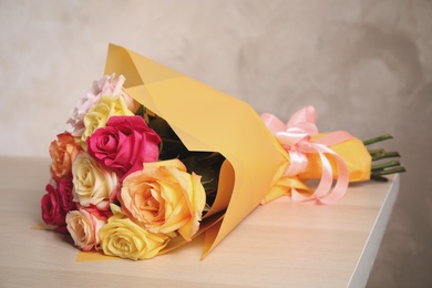 Luxury bouquet of fresh roses on wooden table