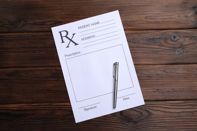 Photo of Medical prescription form with empty fields and pen on wooden table, top view