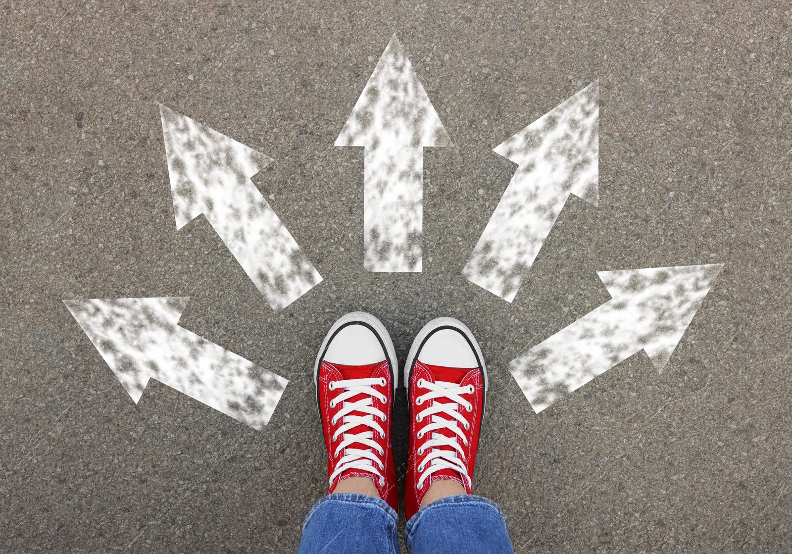 Image of Choosing future profession. Girl standing in front of drawn signs on asphalt, top view. Arrows pointing in different directions symbolizing diversity of opportunities