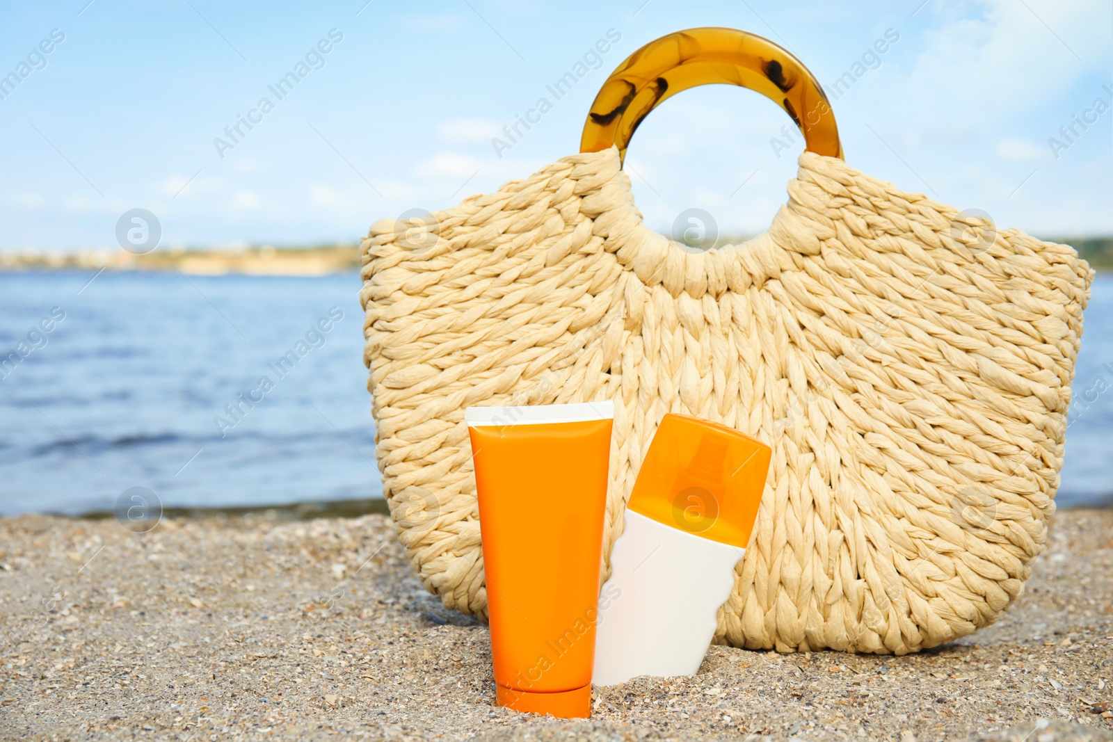 Photo of Composition with bottles of sun protection body cream on beach