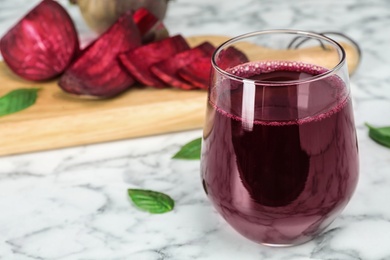 Glass with fresh healthy beet juice on table