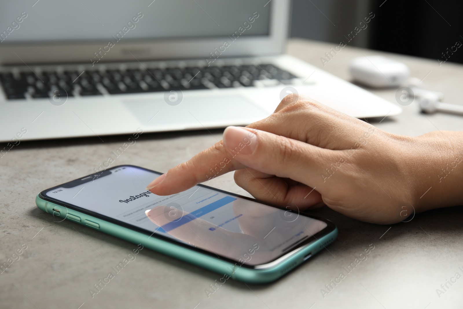 Photo of MYKOLAIV, UKRAINE - JULY 9, 2020: Woman holding Iphone 11 with Instagram app on screen at table, closeup