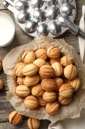 Bowl of delicious nut shaped cookies on wooden table, flat lay