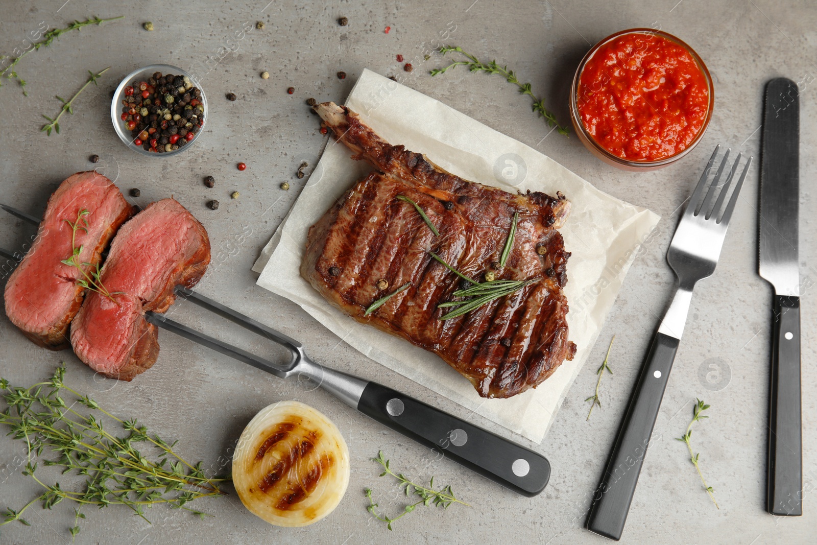 Photo of Flat lay composition with grilled meat steak on grey table