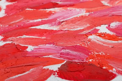 Photo of Beautiful strokes of bright oil paints on white canvas as background, closeup