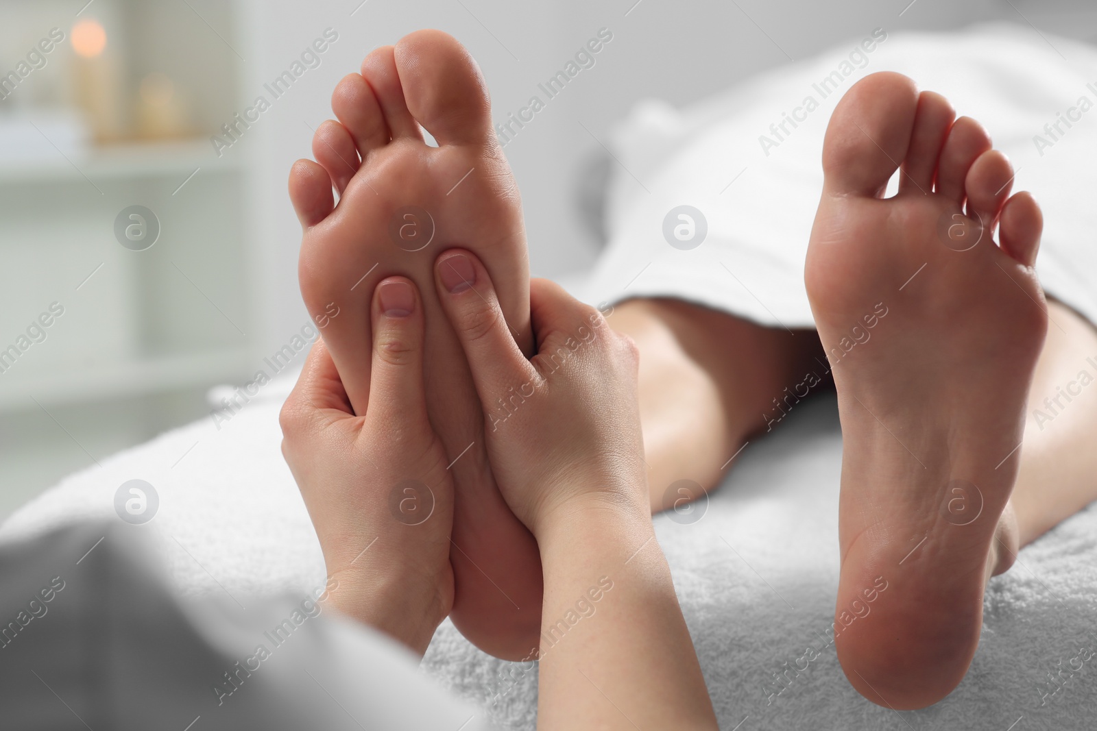 Photo of Woman receiving foot massage in spa salon, closeup