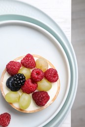 Delicious tartlet with berries on white table, top view