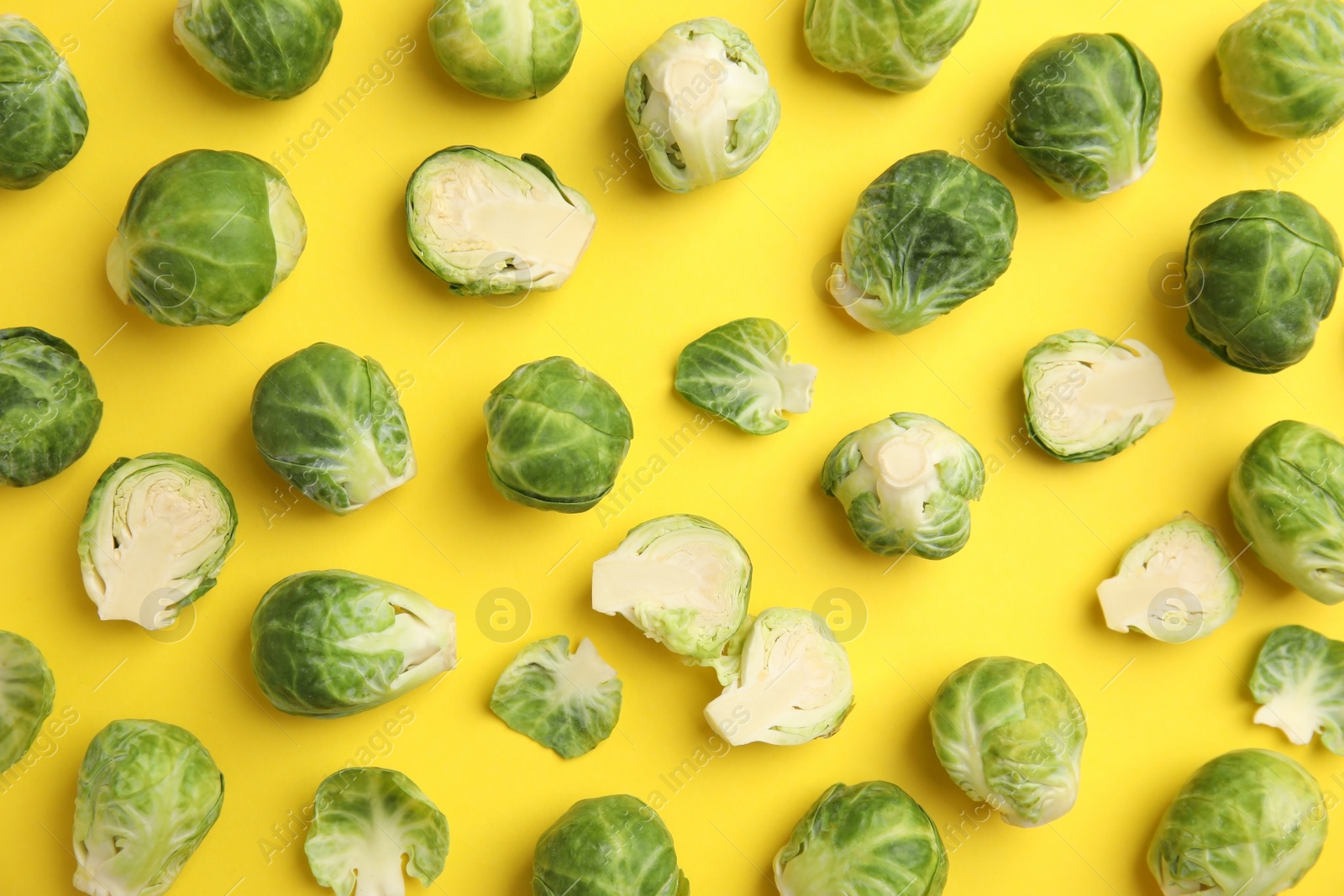 Photo of Fresh Brussels sprouts on yellow background, flat lay