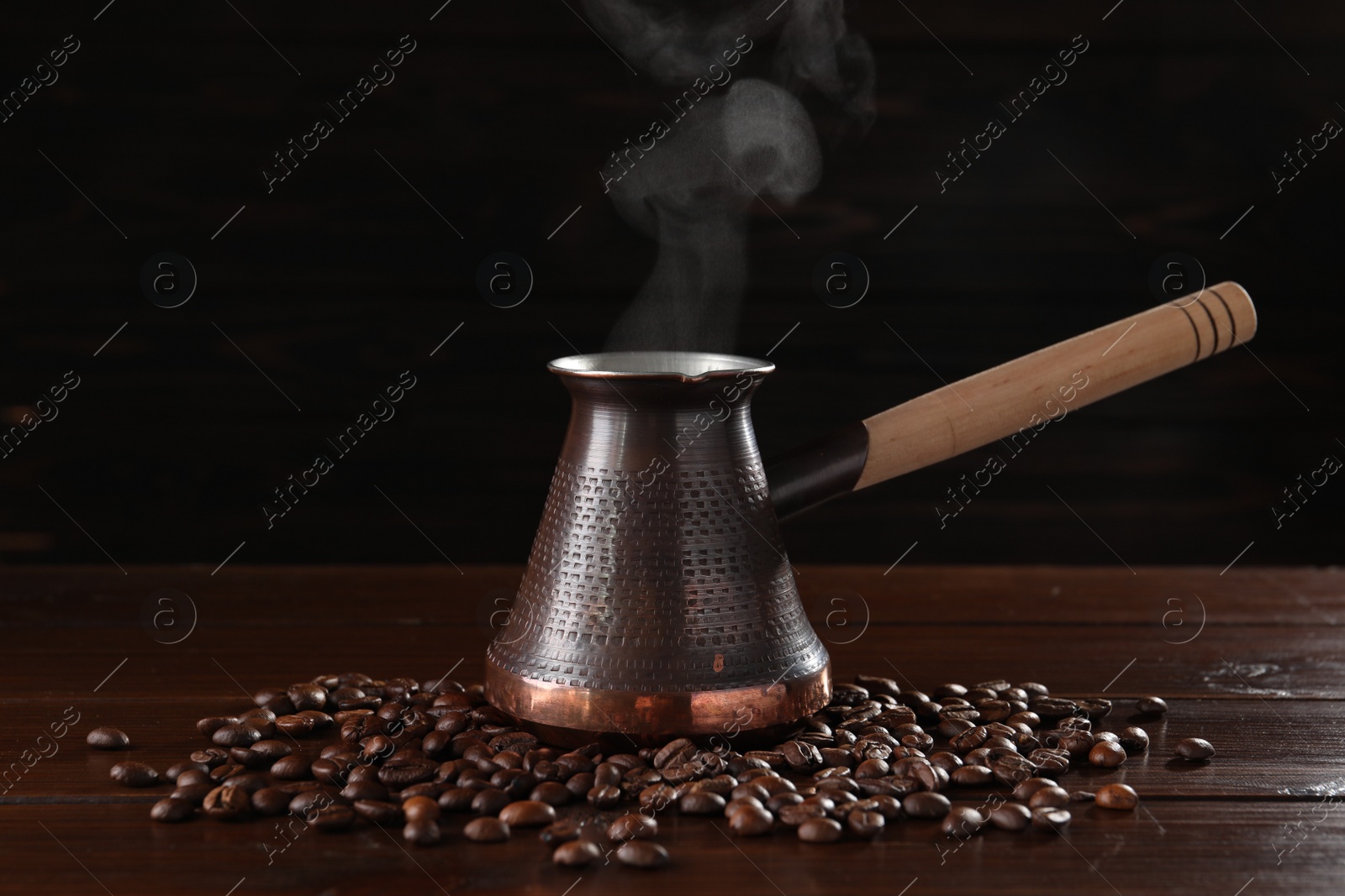 Photo of Turkish coffee in cezve and beans on wooden table