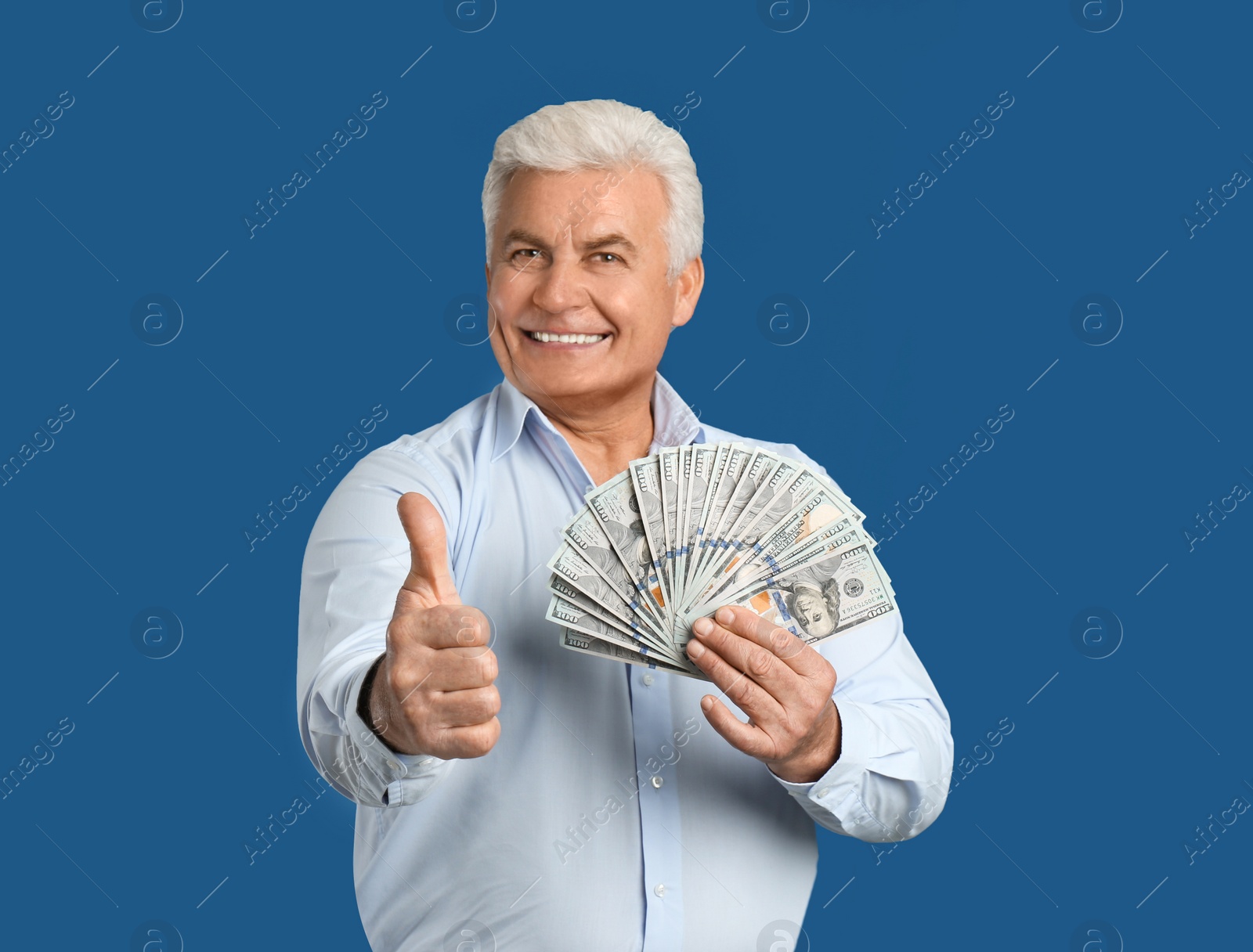 Photo of Happy senior man with cash money on blue background. Space for text