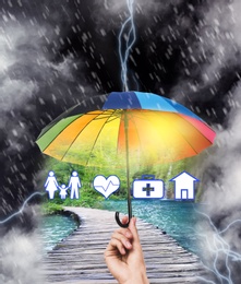 Image of Insurance concept. Woman protecting illustrations with rainbow umbrella from storm, closeup