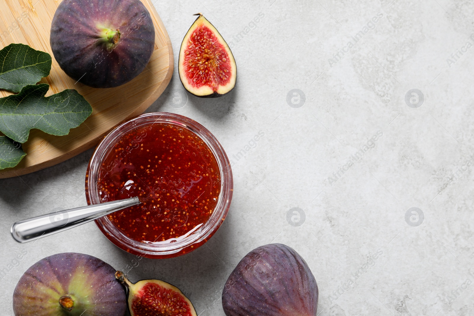 Photo of Jar with tasty sweet jam and fresh figs on white table, flat lay. Space for text