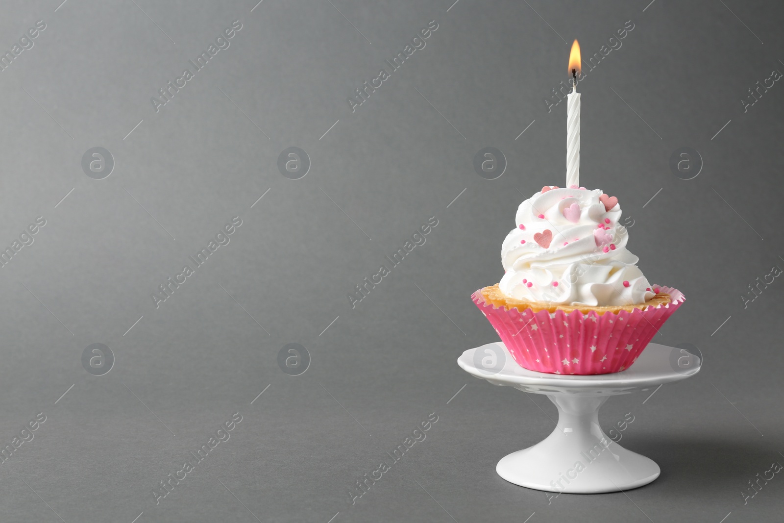 Photo of Delicious cupcake with candle on grey background. Space for text