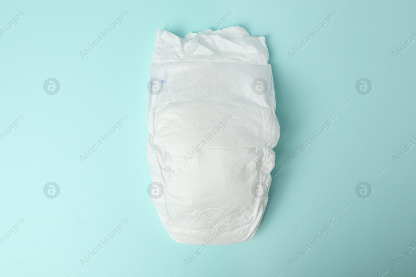 Photo of Baby diaper on light blue background, top view